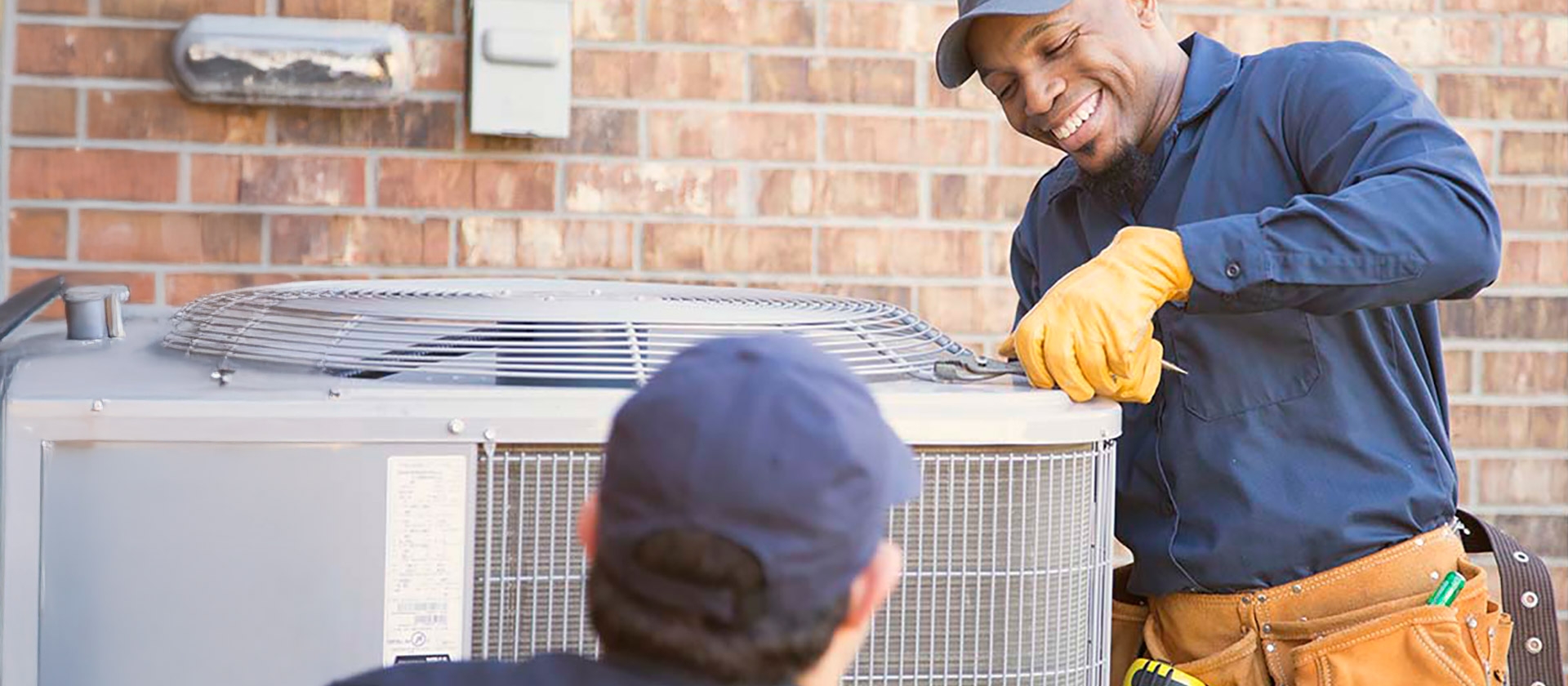 technicians working on a/c unit